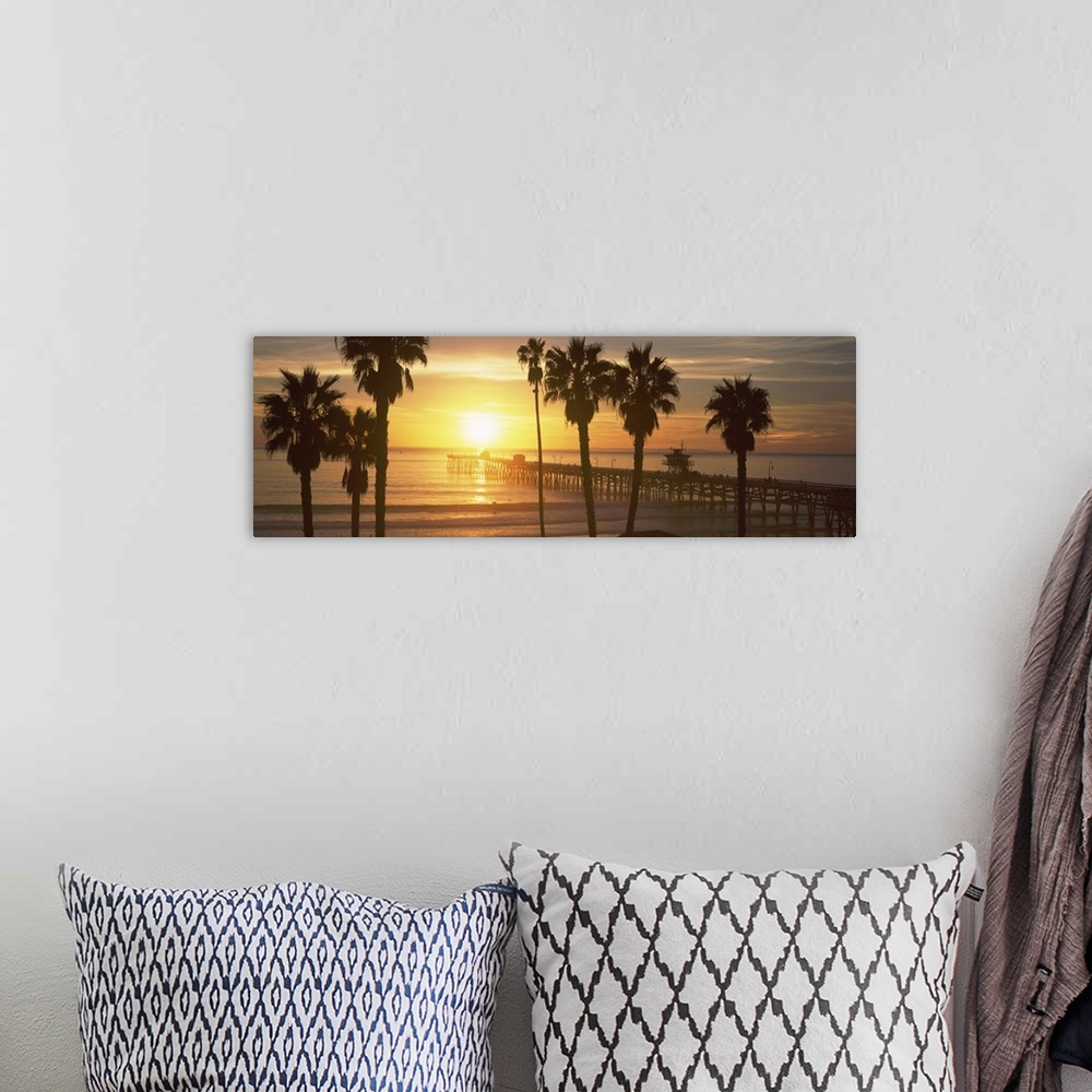 A bohemian room featuring Panoramic photograph of dock stretching into ocean at sunset with palm tree silhouettes in the fo...