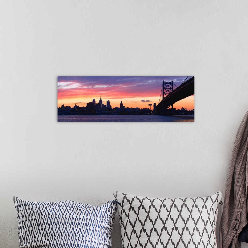 A bohemian room featuring View from the shoreline under the bridge of pastel-colored clouds over the city skyline at dusk.