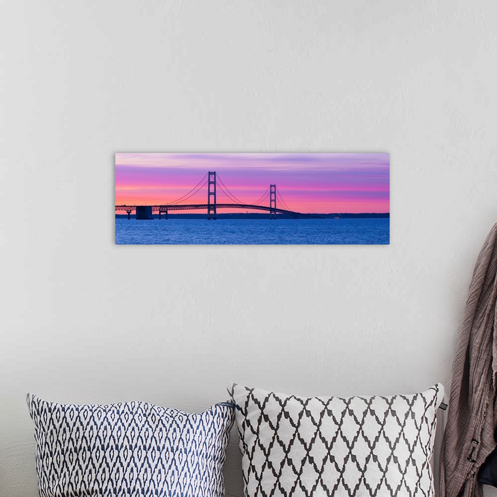 A bohemian room featuring Panoramic photograph shows a long overpass spanning a large body of water and connecting two port...