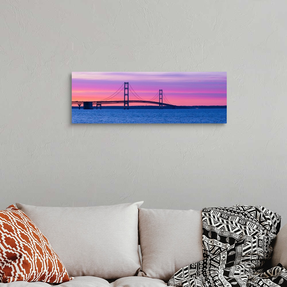 A bohemian room featuring Panoramic photograph shows a long overpass spanning a large body of water and connecting two port...