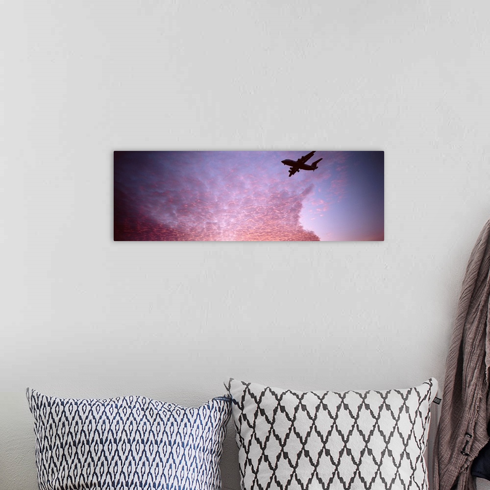 A bohemian room featuring Silhouette of an airplane flying in the sky