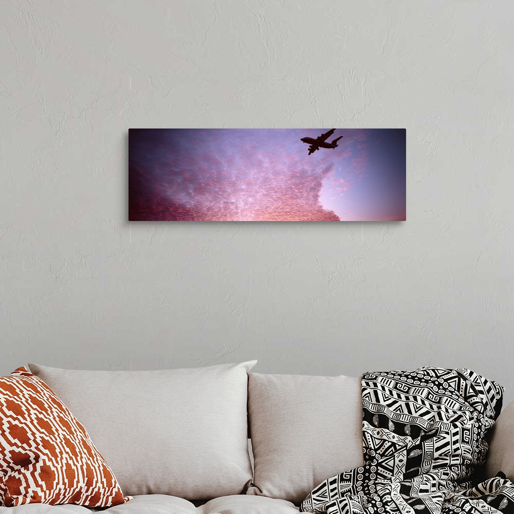 A bohemian room featuring Silhouette of an airplane flying in the sky
