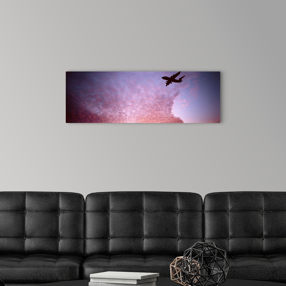 A modern room featuring Silhouette of an airplane flying in the sky