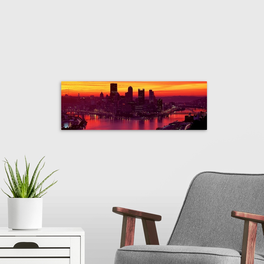A modern room featuring Panoramic photograph of the view of the Pittsburgh skyline from down the Ohio River at sunset and...