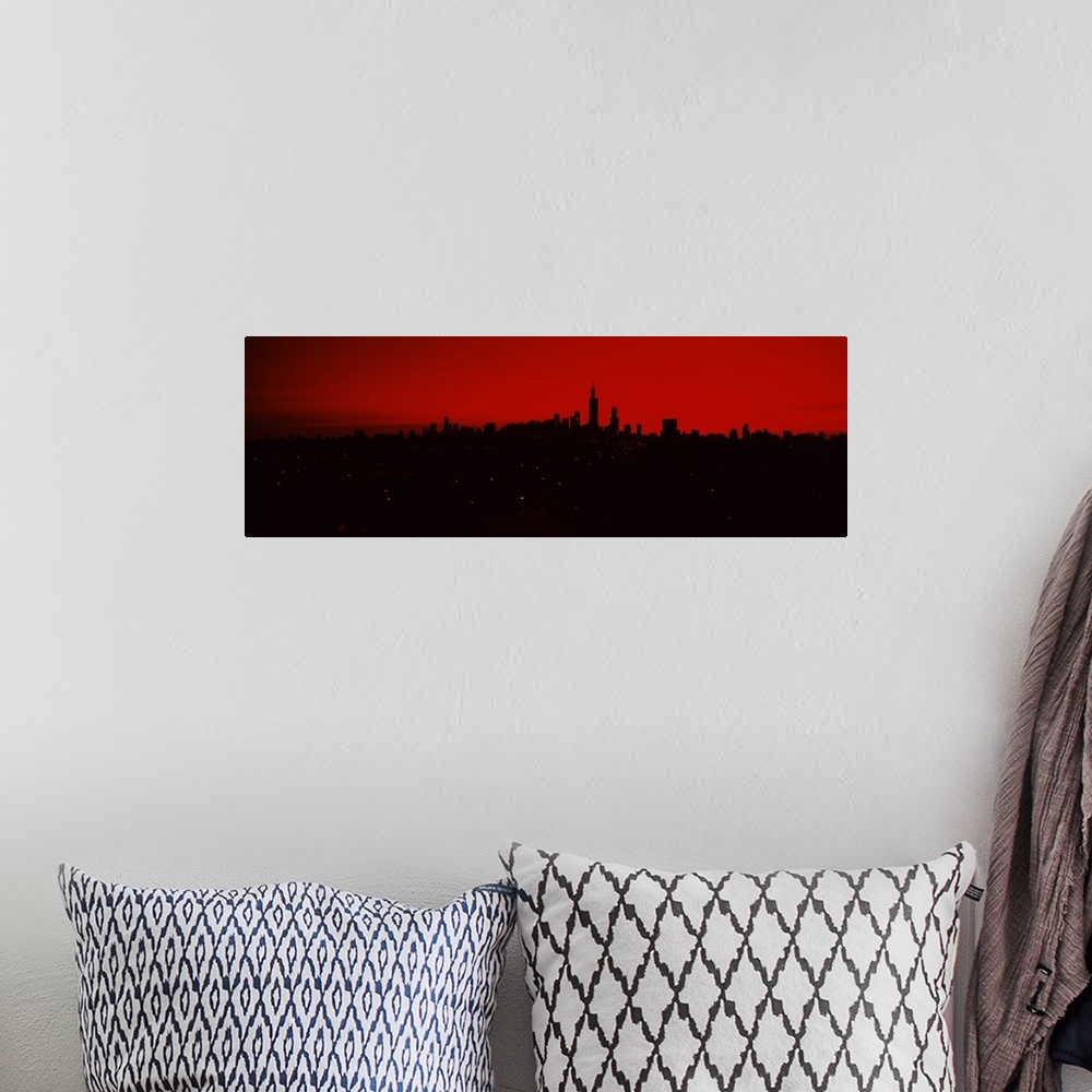 A bohemian room featuring Panoramic photo of a dark silhouetted cityscape against a warm sky.