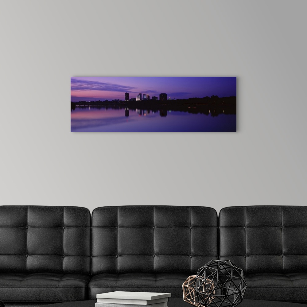 A modern room featuring Panoramic photograph taken of buildings sitting on the Arkansas river that are silhouetted by the...