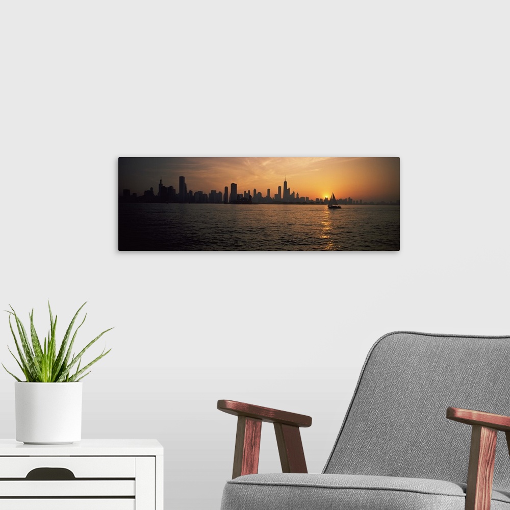 A modern room featuring Panoramic photograph on a large canvas of a silhouetted Chicago skyline on the horizon of Lake Mi...