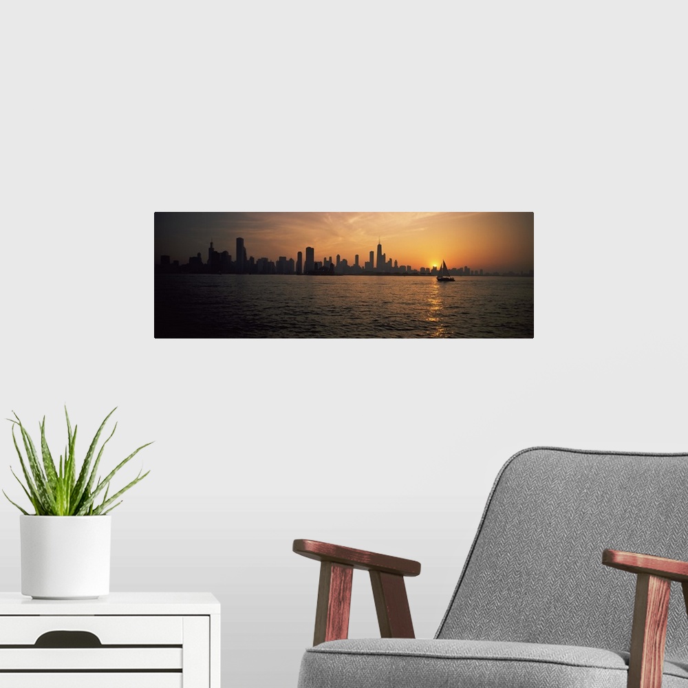 A modern room featuring Panoramic photograph on a large canvas of a silhouetted Chicago skyline on the horizon of Lake Mi...