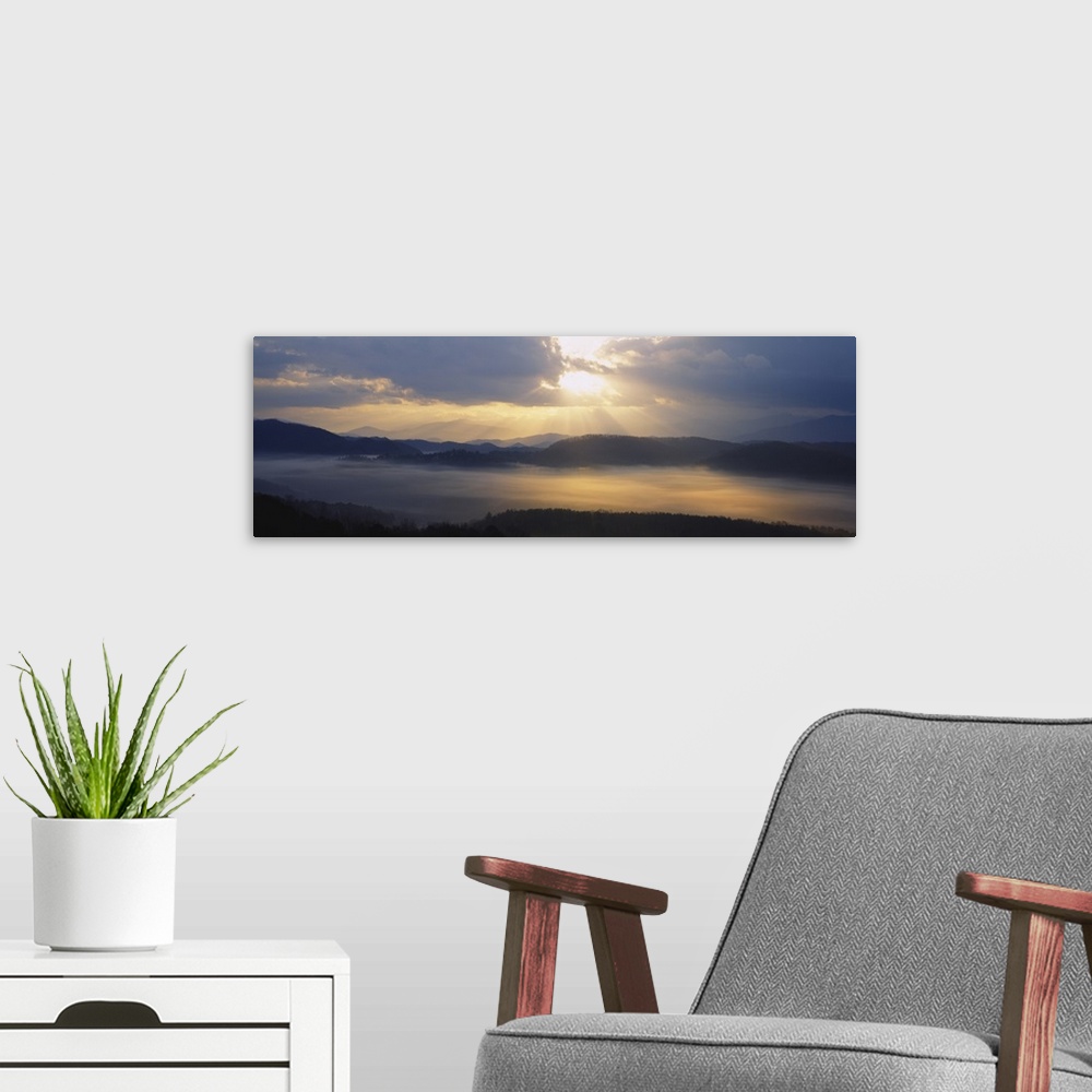 A modern room featuring Wide angle photograph of the sun rising over the mountains, and the vast landscape of the Great S...
