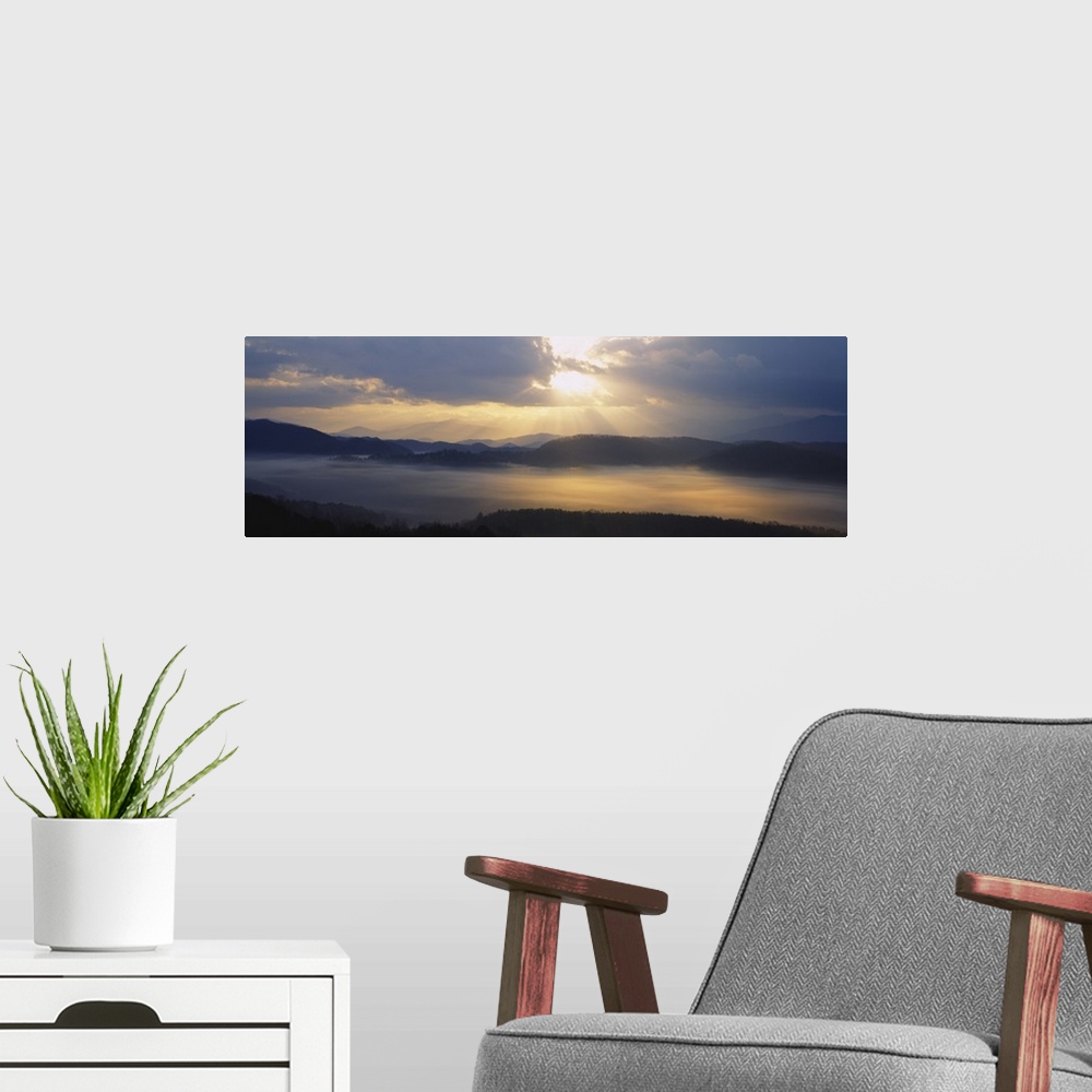 A modern room featuring Wide angle photograph of the sun rising over the mountains, and the vast landscape of the Great S...