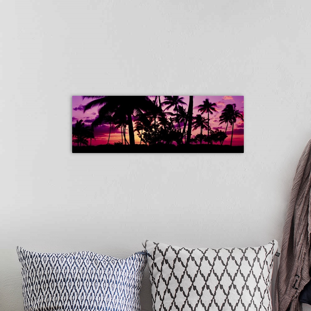 A bohemian room featuring Oversized, landscape photograph of a vivid sunset in Ko Olina, Oahu, Hawaii, with the silhouettes...
