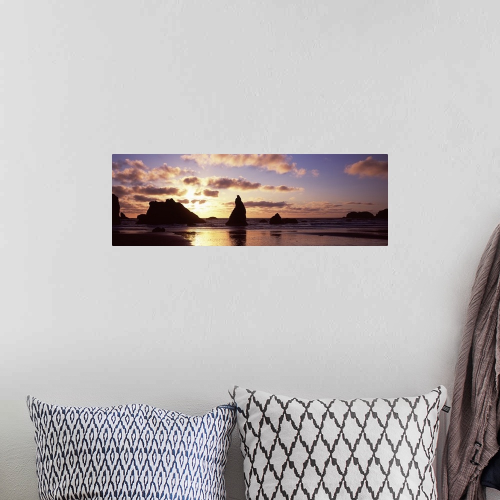 A bohemian room featuring Photo of the sun setting behind rock formations sticking up in the shallow waters of the ocean cr...