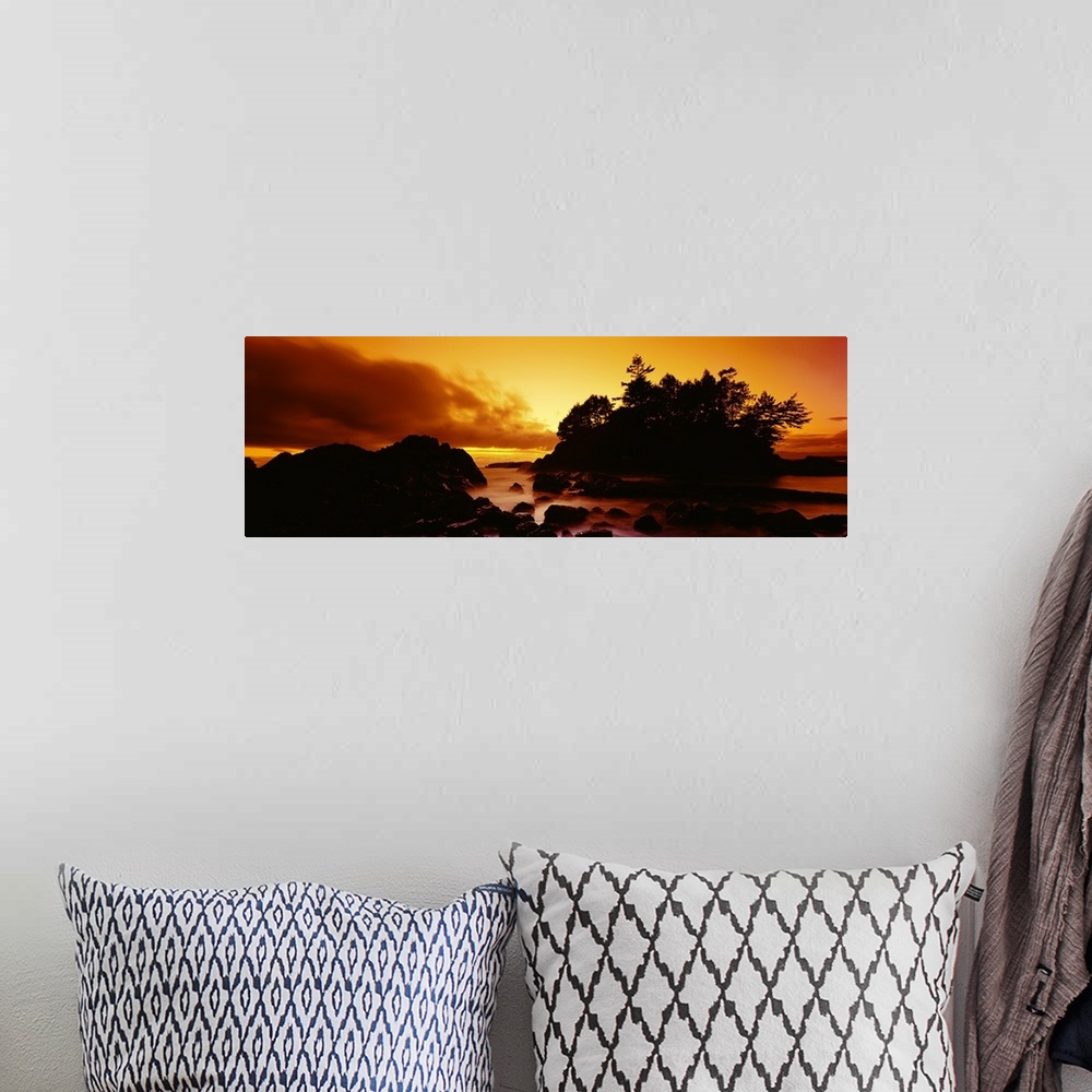 A bohemian room featuring Panoramic photograph displays a sunburnt sky as the sun begins to set over the profile of a rocky...