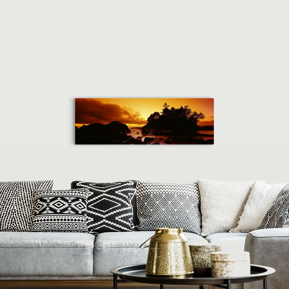 A bohemian room featuring Panoramic photograph displays a sunburnt sky as the sun begins to set over the profile of a rocky...