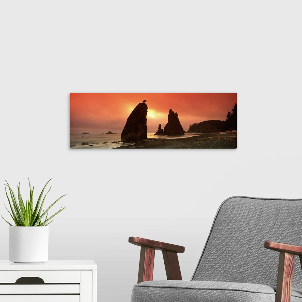 A modern room featuring This is a panoramic photograph of the sun setting behind enormous rock formations on this rocky N...