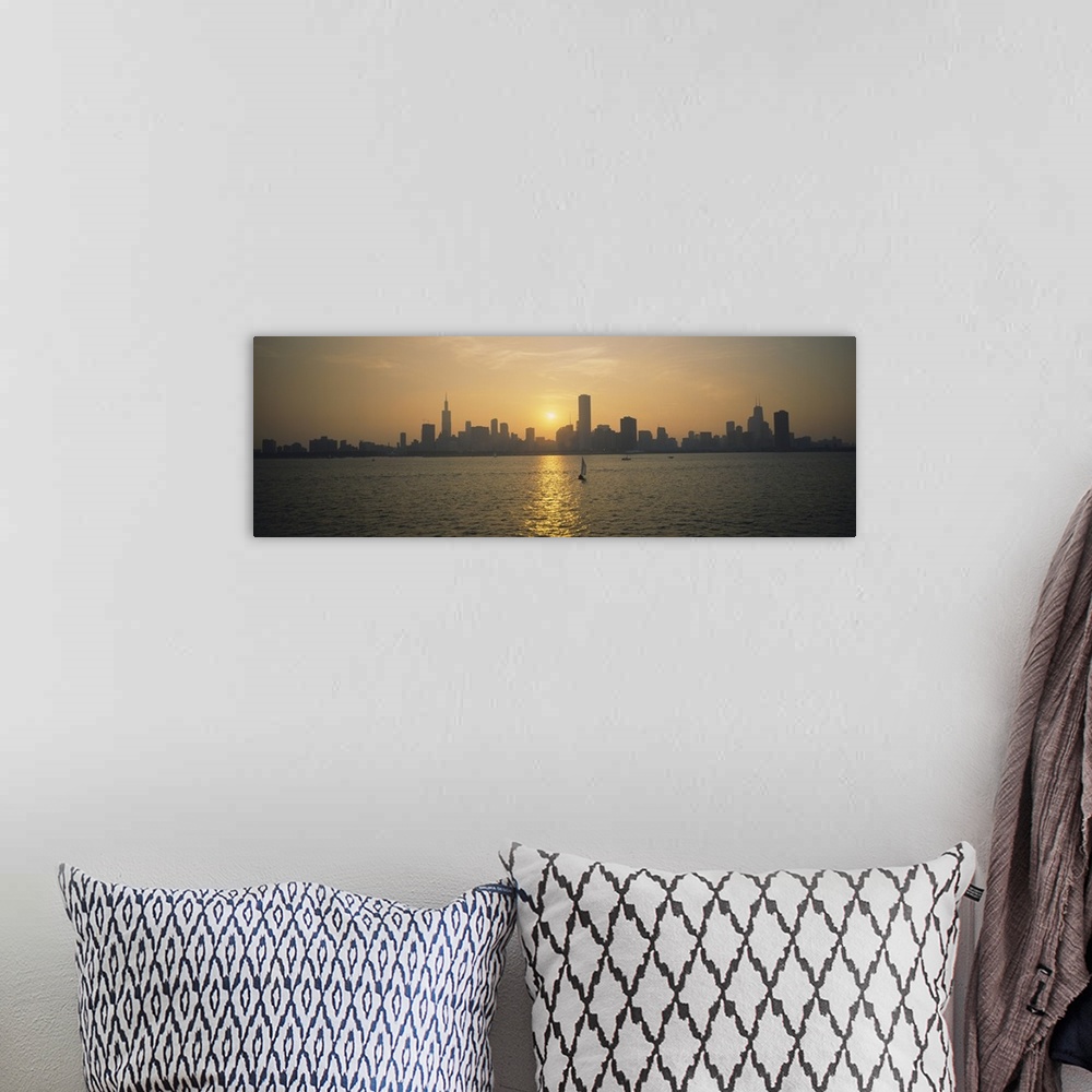 A bohemian room featuring Wide angle photograph of a distant Chicago skyline, silhouetted by the setting sun, several small...
