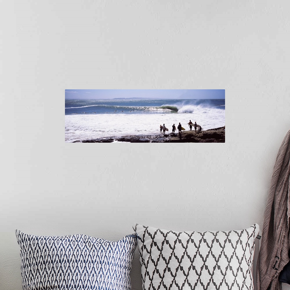 A bohemian room featuring Panoramic photograph of beachgoers at water's edge with waves and ocean in the distance.