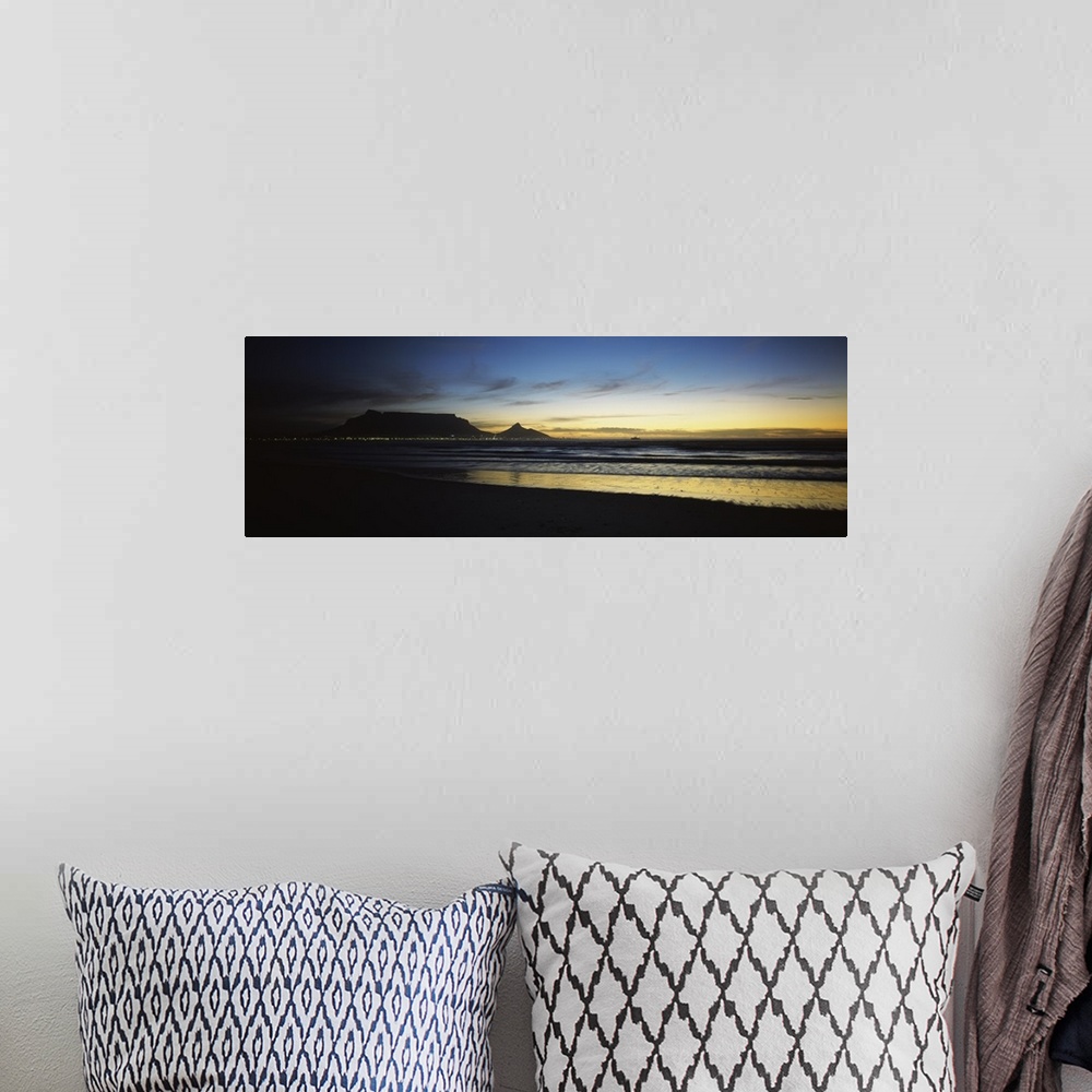 A bohemian room featuring Panoramic photograph of shoreline at dusk under a cloudy sky with mountain range silhouette in th...
