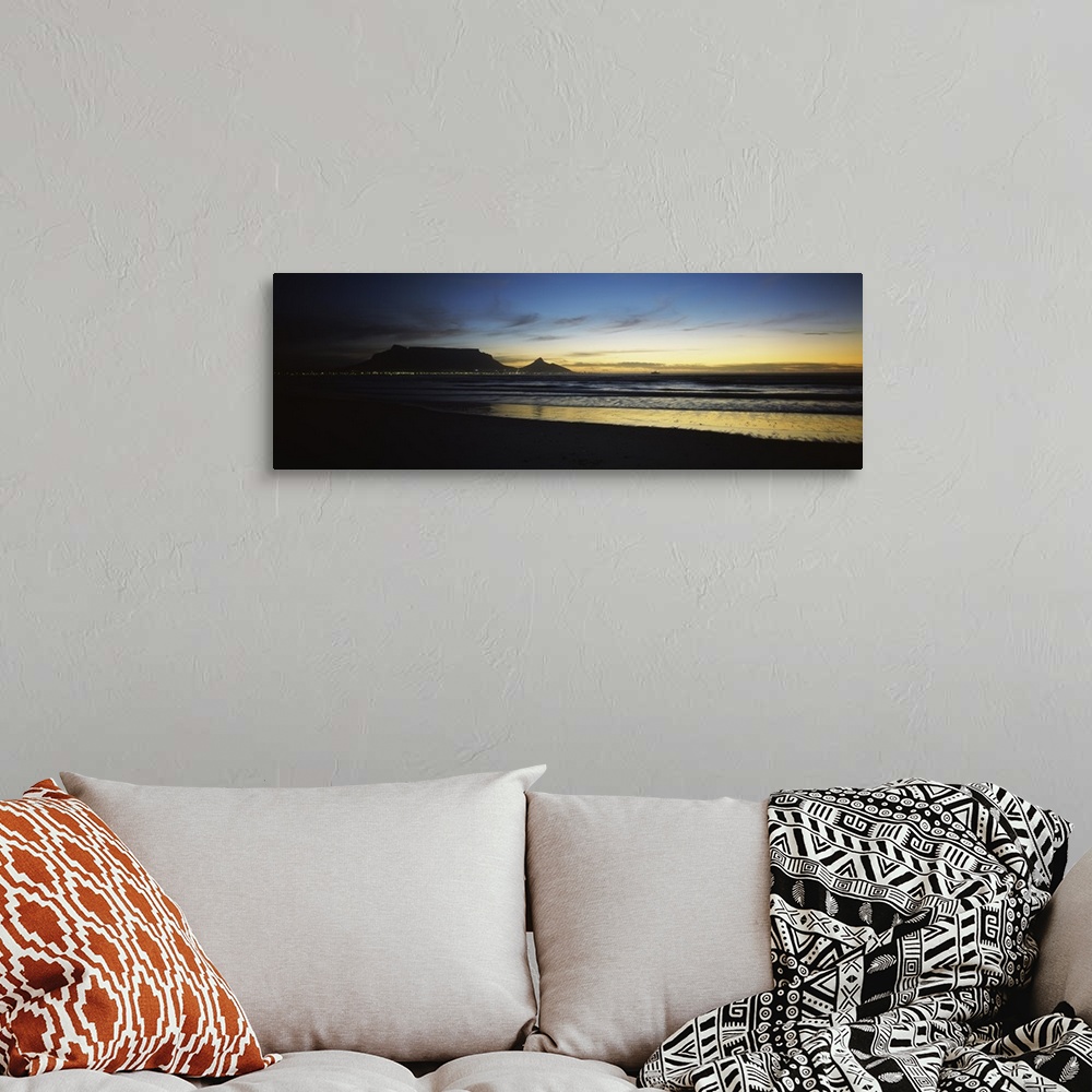 A bohemian room featuring Panoramic photograph of shoreline at dusk under a cloudy sky with mountain range silhouette in th...