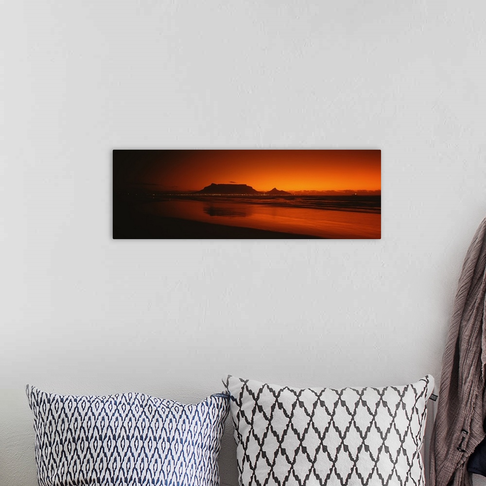 A bohemian room featuring Wide angle, large photograph of sunset at the shoreline near Table Bay in Western Cape Province, ...