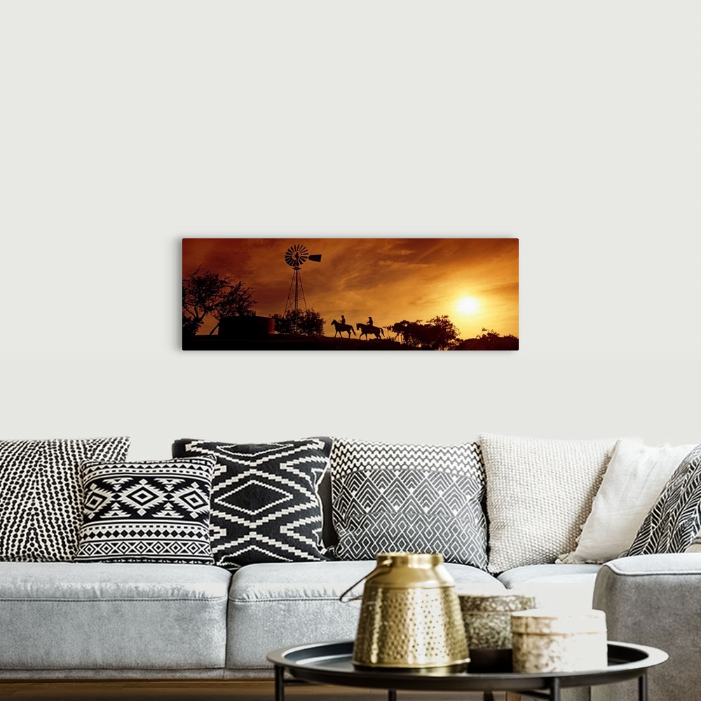 A bohemian room featuring Landscape, panoramic artwork of a hill with a windmill perched at the top on a farm at twilight.