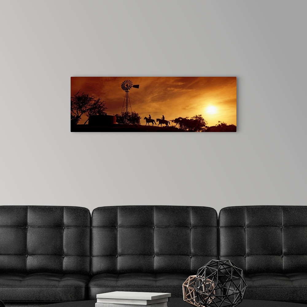 A modern room featuring Landscape, panoramic artwork of a hill with a windmill perched at the top on a farm at twilight.