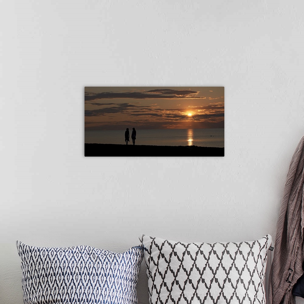A bohemian room featuring Panoramic photo of the silhouette of two people walking along the ocean at sunset.