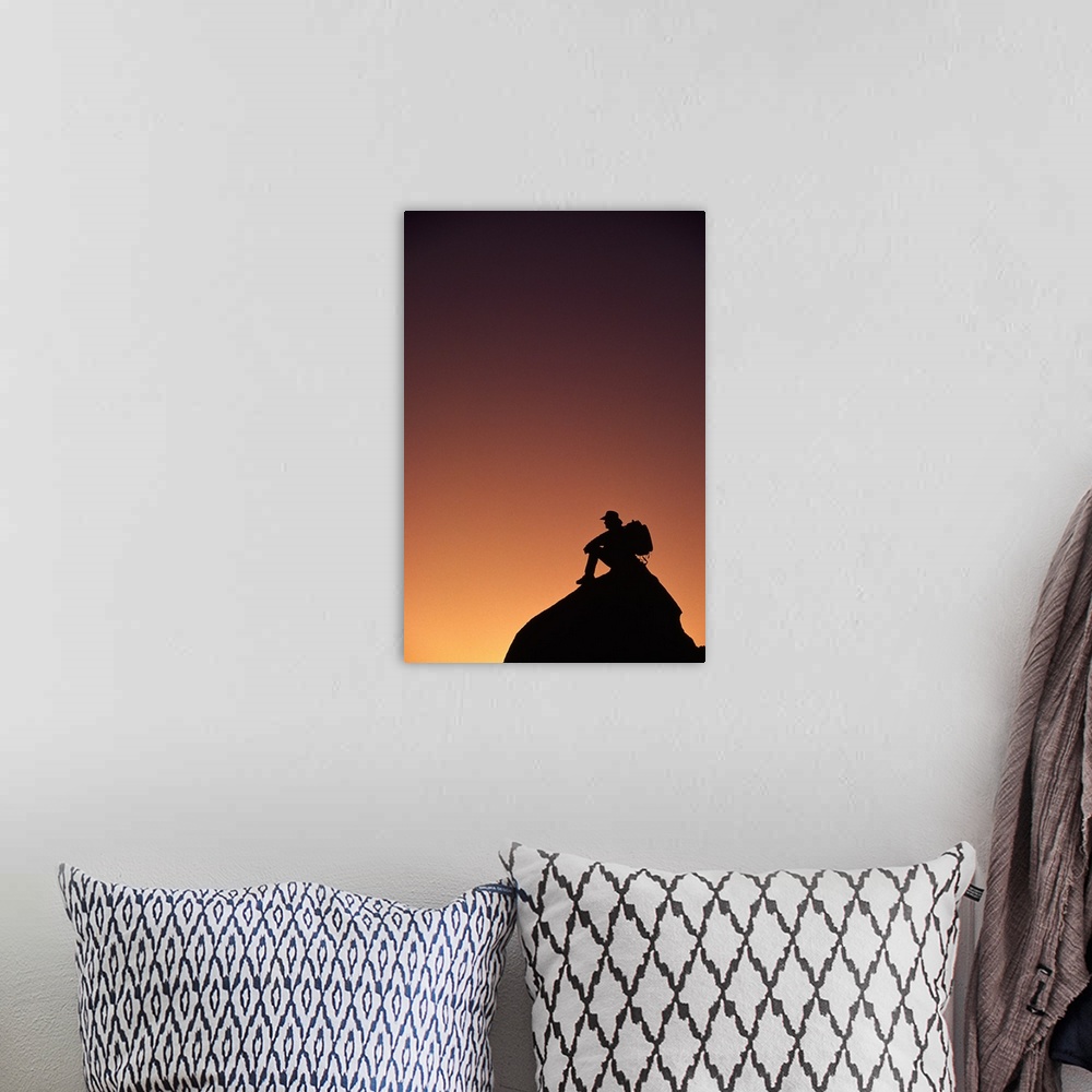 A bohemian room featuring Silhouetted backpacker on rock, sunset light, Utah
