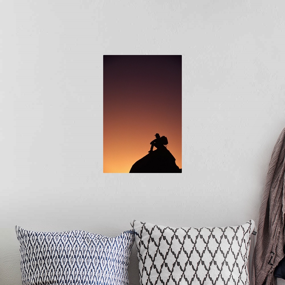 A bohemian room featuring Silhouetted backpacker on rock, sunset light, Utah