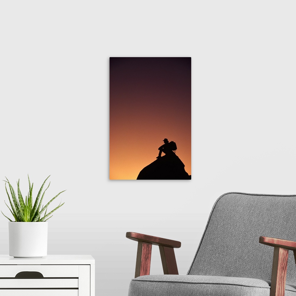 A modern room featuring Silhouetted backpacker on rock, sunset light, Utah