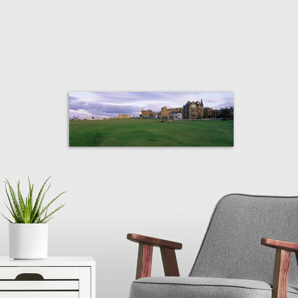 A modern room featuring Panoramic picture taken of buildings that are a part of a famous golf club in Scotland.
