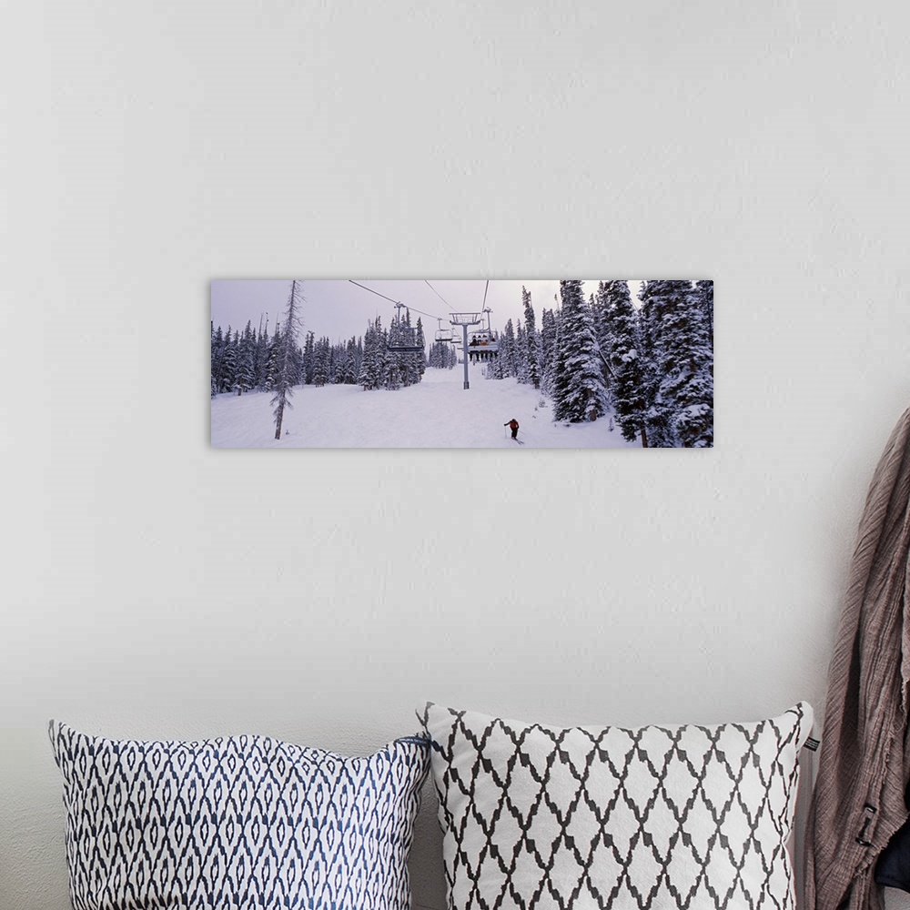 A bohemian room featuring Panoramic photograph on a giant canvas of a ski lift surrounded by snow covered trees, one skier ...