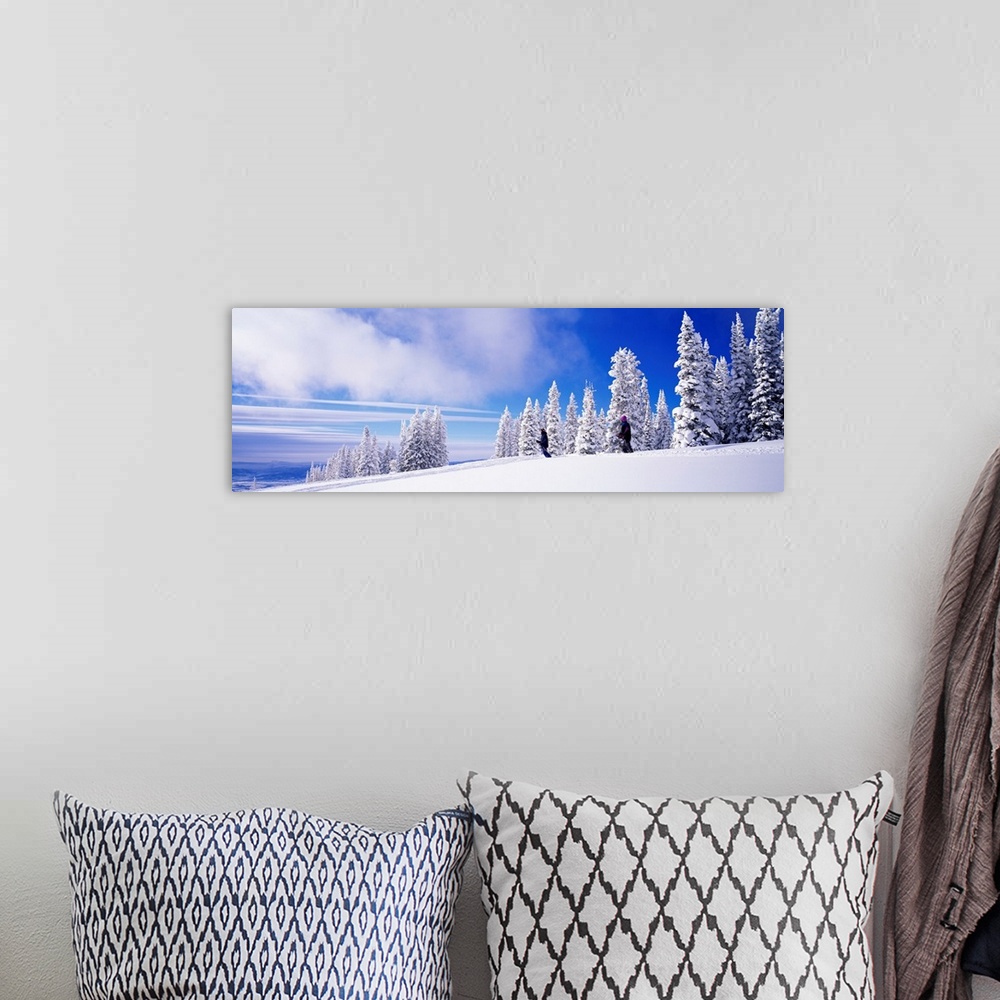 A bohemian room featuring Panoramic photograph focuses on two people skiing on a mountain recently blanketed with fresh sno...