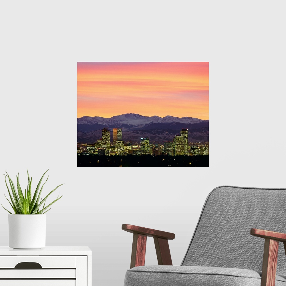 A modern room featuring Large photograph taken of the Denver, Colorado skyline at dusk.  The snow covered mountains in th...