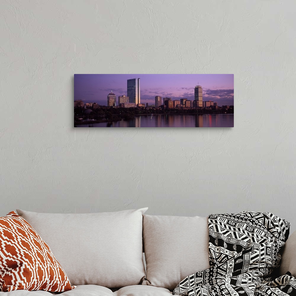 A bohemian room featuring A large panoramic photograph of the Boston skyline showing the river and trees lining the edge in...