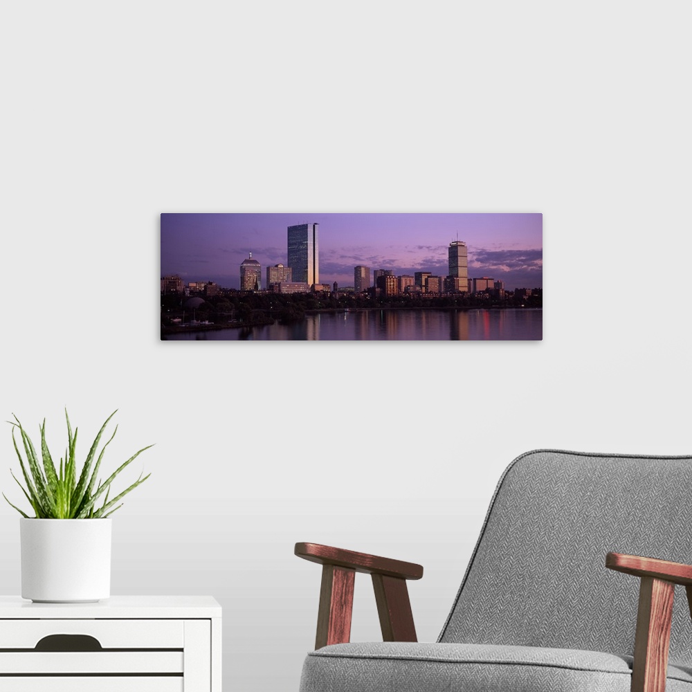A modern room featuring A large panoramic photograph of the Boston skyline showing the river and trees lining the edge in...