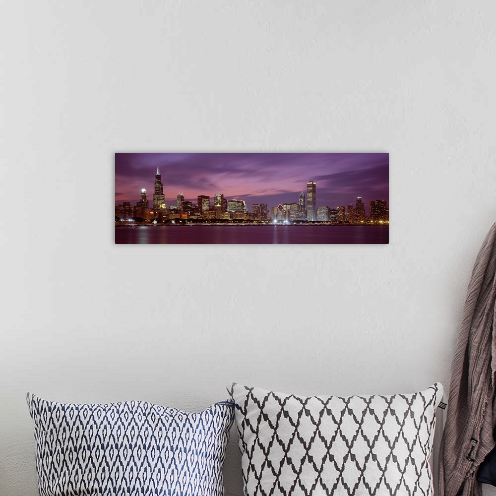 A bohemian room featuring Panoramic photograph displays a horizon filled with tall skyscrapers and buildings at nighttime f...