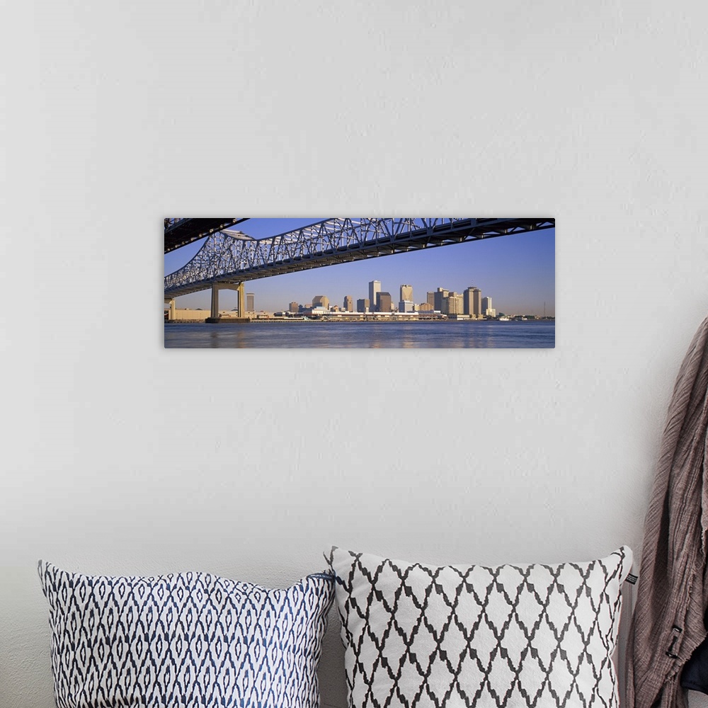 A bohemian room featuring Part of the New Orleans skyline is photographed from a distance below the Crescent City Connectio...
