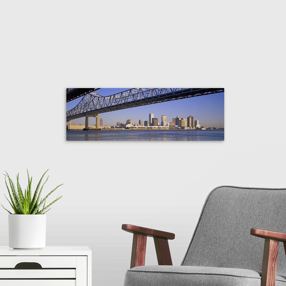 A modern room featuring Part of the New Orleans skyline is photographed from a distance below the Crescent City Connectio...