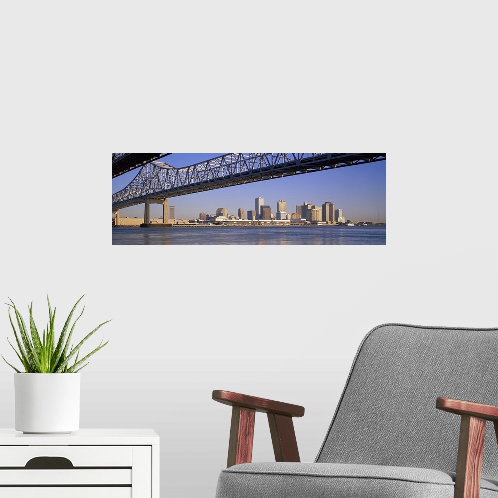 A modern room featuring Part of the New Orleans skyline is photographed from a distance below the Crescent City Connectio...