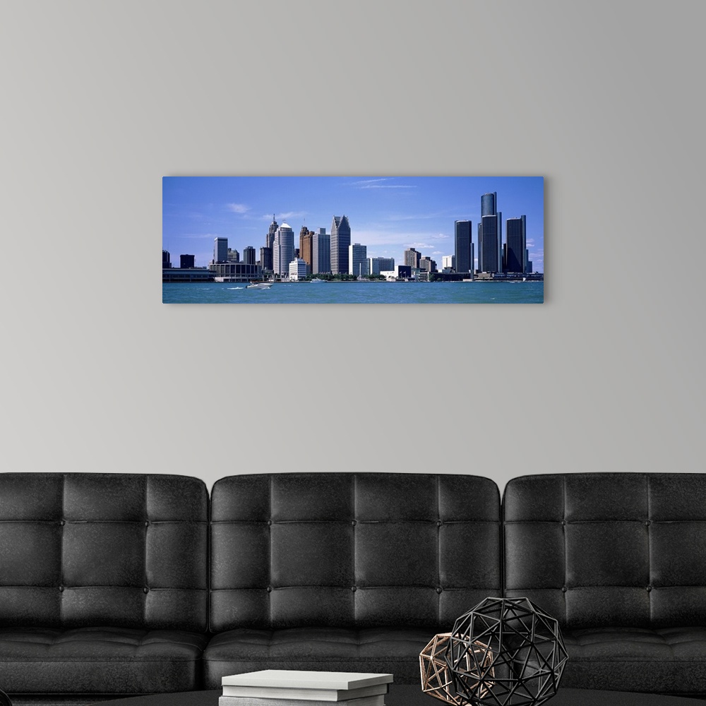 A modern room featuring Panoramic photograph taken of the Detroit skyline during the day with a body of water shown in fr...