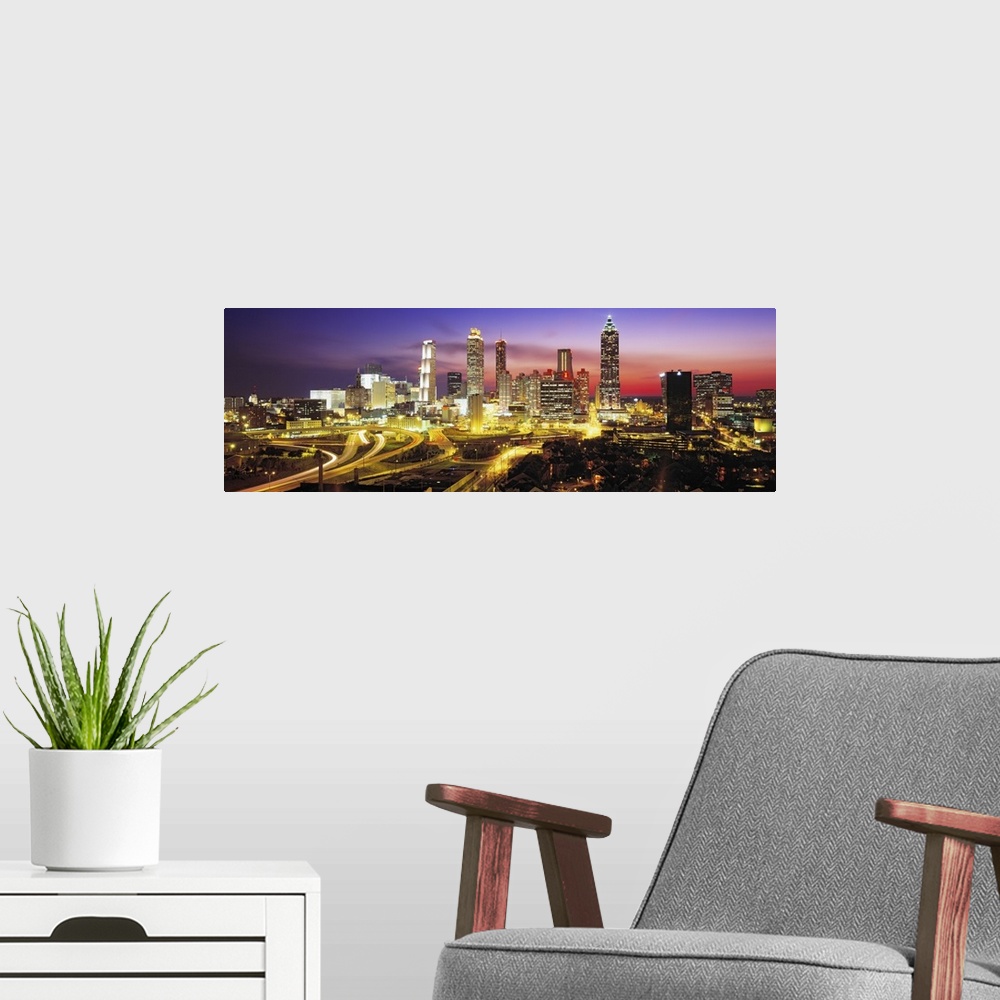 A modern room featuring Panoramic photograph of cityscape at night with buildings and streets lit up in the dark colorful...