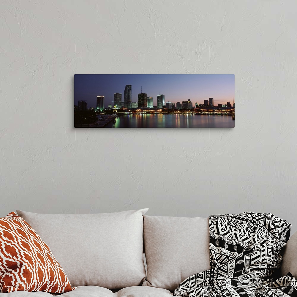 A bohemian room featuring Long print of a cityscape along the water in Florida lit up at dusk.