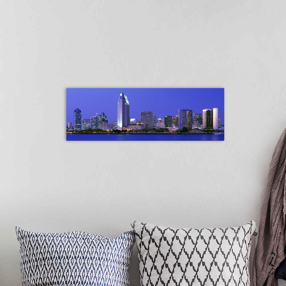 A bohemian room featuring Skyscrapers in San Diego are illuminated and photographed in panoramic view from across a body of...