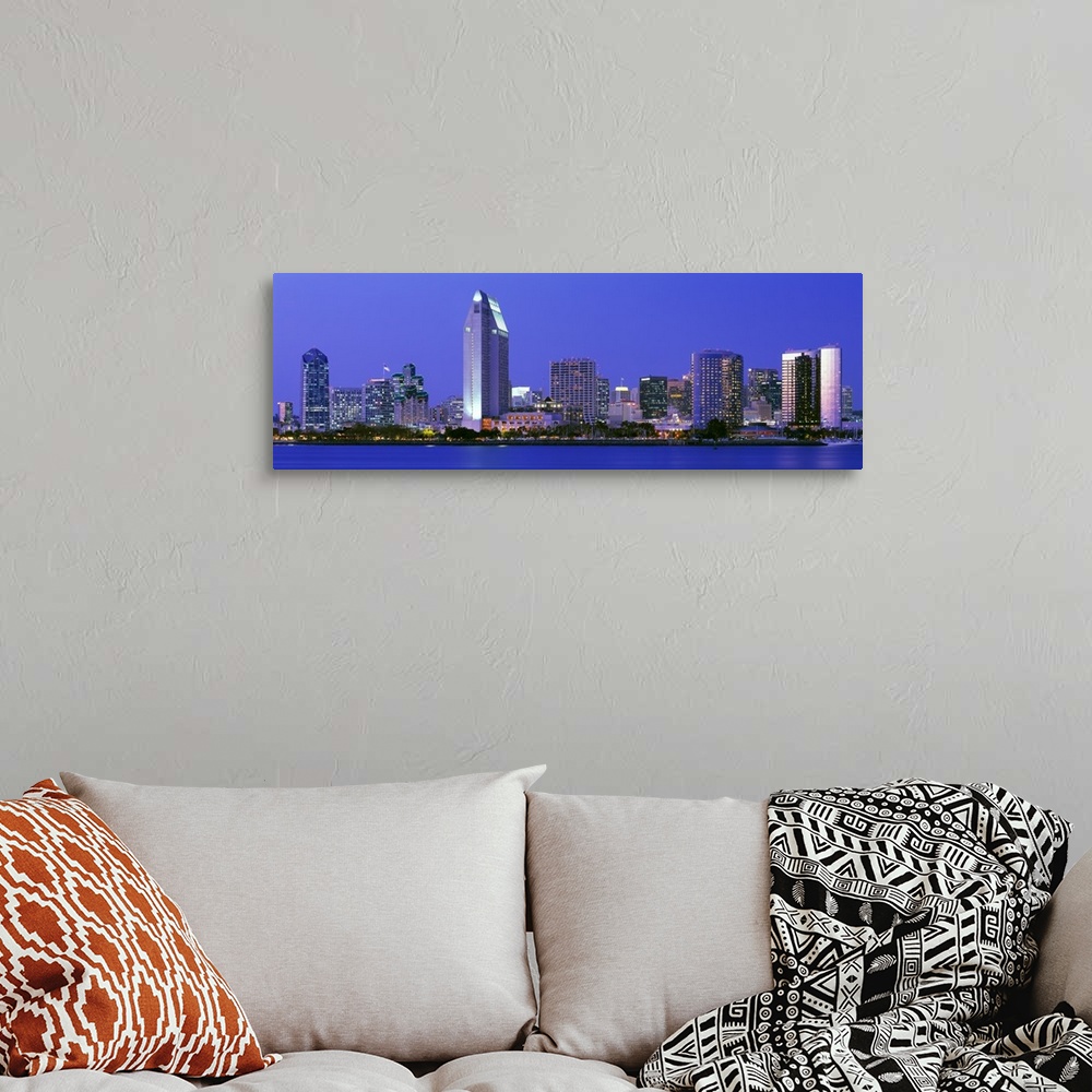 A bohemian room featuring Skyscrapers in San Diego are illuminated and photographed in panoramic view from across a body of...