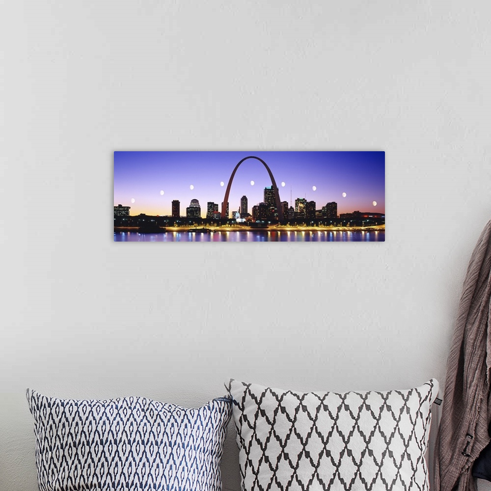 A bohemian room featuring Colorful panoramic photograph of lit up skyline at night with Gateway Arch and waterfront.  The b...