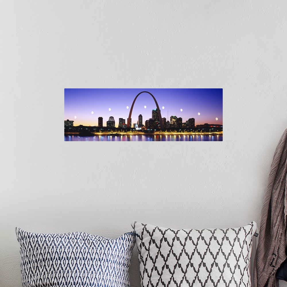 A bohemian room featuring Colorful panoramic photograph of lit up skyline at night with Gateway Arch and waterfront.  The b...