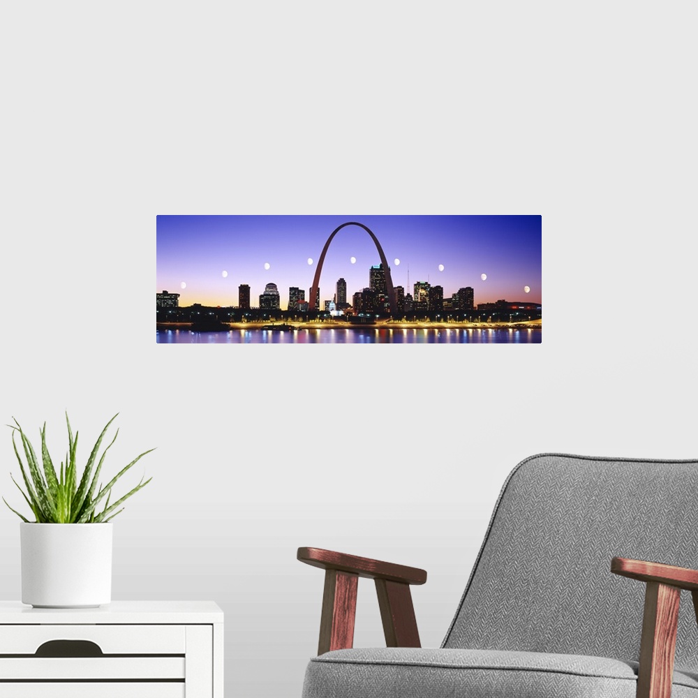 A modern room featuring Colorful panoramic photograph of lit up skyline at night with Gateway Arch and waterfront.  The b...