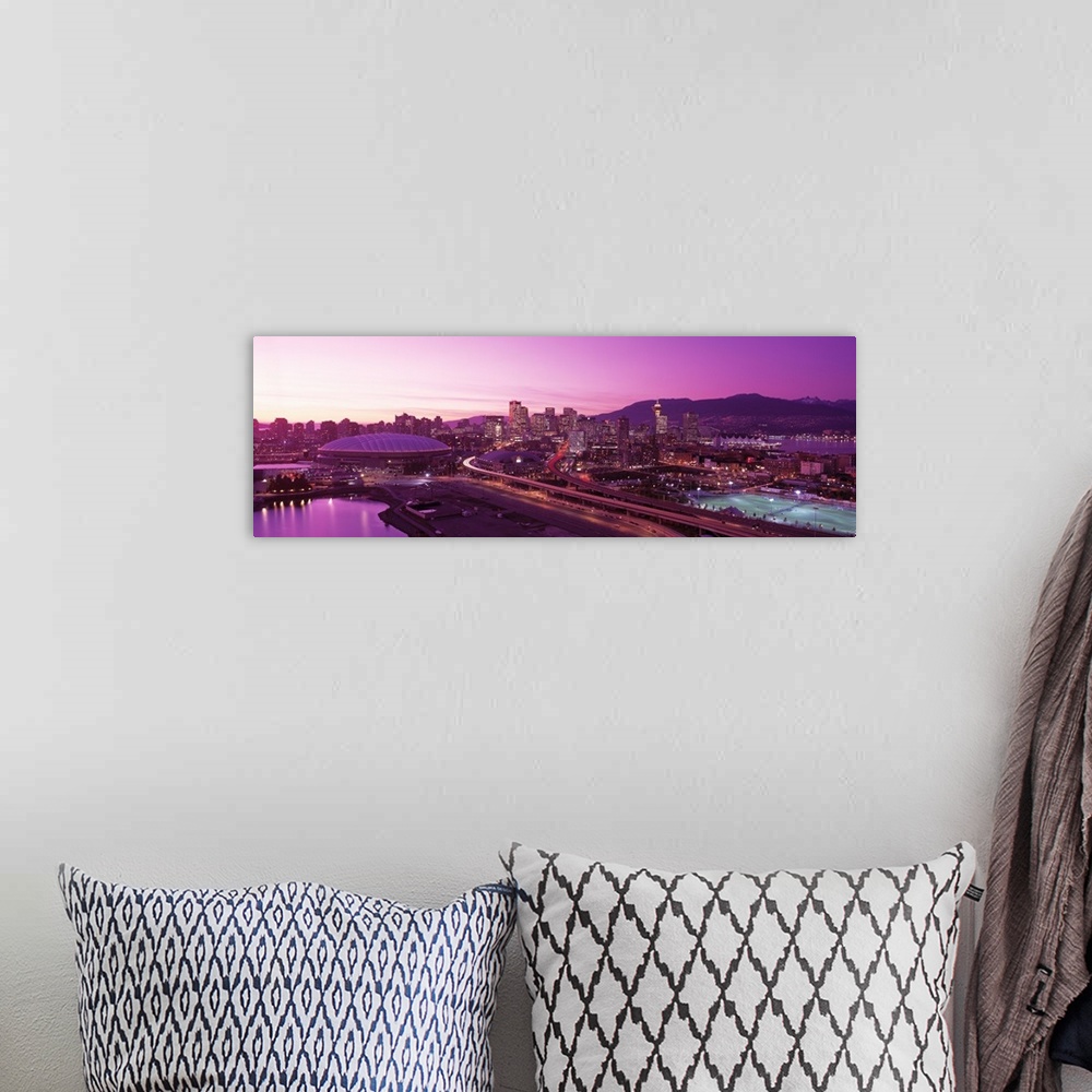 A bohemian room featuring An aerial panoramic photograph taken of the skyline in Vancouver that has a purple hue from the s...