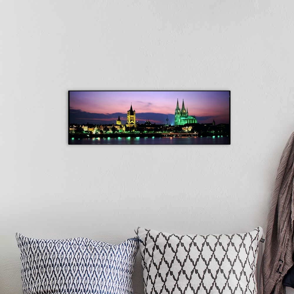 A bohemian room featuring Panoramic photo of a German cityscape lit up at night on the water.